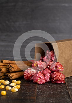 A Bag of Dark Red Cinnamon Popcorn on a Wooden Kitchen Table