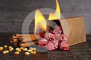 A Bag of Dark Red Cinnamon Popcorn on a Wooden Kitchen Table