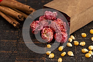 A Bag of Dark Red Cinnamon Popcorn on a Wooden Kitchen Table