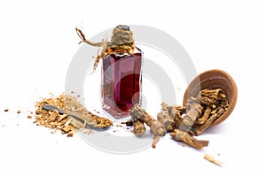 Dark red colored essence of nannari or Indian sarsaparilla in a transparent bottle isolated on white. photo