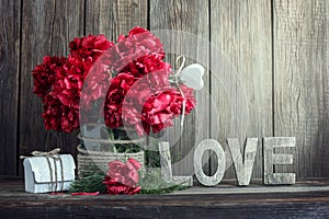 Dark red peonies in a decorated glass jar