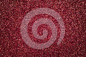 Dark red sparkling background from small sequins, closeup. Brilliant backdrop