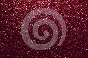 Dark red sparkling background from small sequins, closeup. Brilliant backdrop