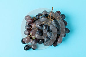 Dark ripe grape on blue background, close up photo