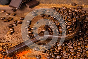 Dark roasted pure arabica coffee beans and ground coffe on the w