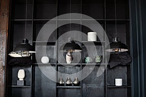 Dark room with Three modern lamps over table. Three modern black ceiling lamps hang in room, close-up. Loft room interior. Metal c