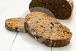 Dark rue bread with seeds on a white background