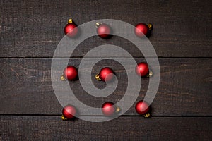 Dark rustic wood table flatlay - Christmas background with red christmas ornaments. Top view with free space for copy text