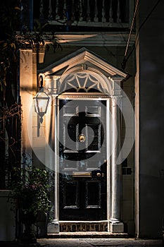 A dark and scarry black door at night