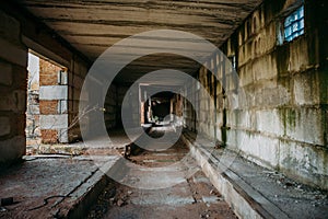 Dark scary corridor in abandoned industrial ruined brick factory, creepy interior