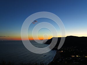 Dark scenic coastline by astronomical twilight with glowing horizon