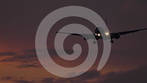 Dark silhouette of an airplane at sunset