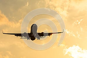 Dark silhouette of an airplane at sunset approach in the airport of a beautiful beautiful sky.