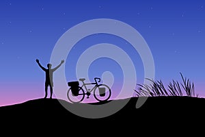 Dark silhouette of touring bike cyclist with bicycle on mountain with sunset background