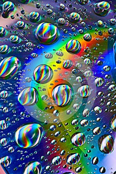Dark silvery swirling water drops in cosmic rainbow Saturn ring in psychedelic background asset