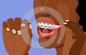 Dark skinned afro young woman with braces uses super floss. Daily dental care. Correction of bite and a beautiful smile. Dental