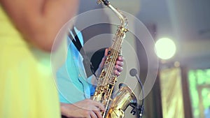 Dark-skinned black woman singer and thin saxophone player performing on stage.