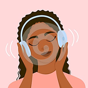 A dark-skinned girl listens to music with headphones, closing her eyes.