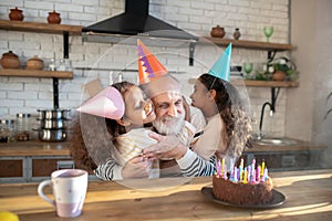 Dark-skinned girls celebrating his granddads bithday and hugging him