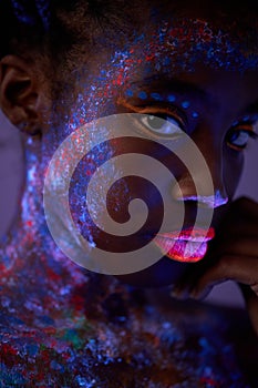 dark skinned woman with colorful abstract make-up on face. unusual, fantastic shoot