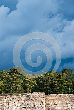 Dark sky and clouds with trees with limestone cliff landscape