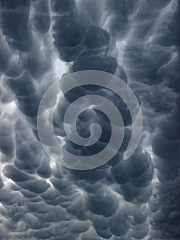 Dark sky by Mammatus clouds in pouch-like shapes