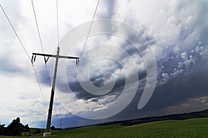 Dark sky over an electricity pylon in a field