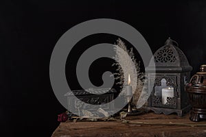 Dark still life with dried roses on wooden table.