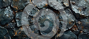 A dark stone surface with intricate patterns, deep cracks, and stunning geological features