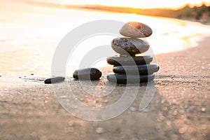 Dark stones on sand near sea at sunset. Zen concept