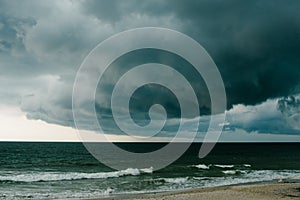 A dark storm cloud hovers over the Atlantic Ocean.