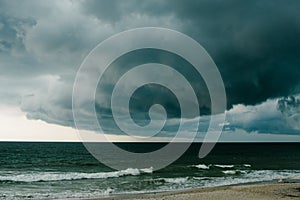 A dark storm cloud hovers over the Atlantic Ocean. photo