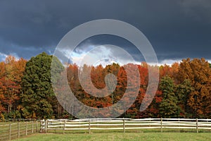 Dark storm clouds over Autumn trees and pasture