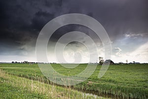 Dark storm clouds over Dutch farmland
