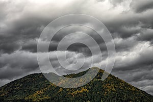 Dark stormy clouds over top of the hill