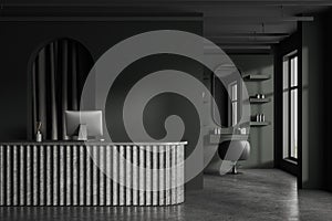 Dark stylish barbershop interior with reception desk, computer and mock up wall