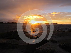 Dark sunrise with high contrast and cloudy sky in Sardinia, Caprera island, Mediterranean vegetation, background with copy space