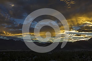 Dark sunset sky with bright colors over a mountain city