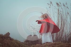Dark and surreal portrait of a red hooded woman