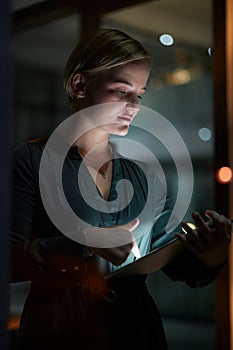 Dark, tablet and woman is working overtime in late in the evening in a modern office for a startup company. Person