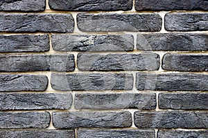 Dark texture of black bricks on the wall of the building