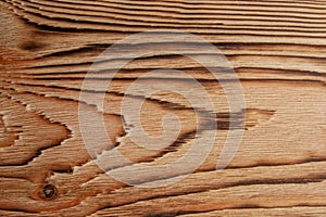 Dark texture of pine board after firing and brushing with a small knot close-up