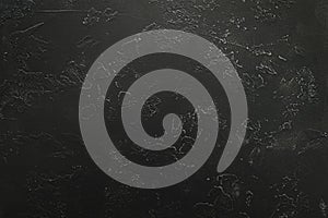 Dark textured surface with abstract markings and subtle rough patterns