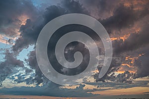 a dark thundercloud on the background of sunset