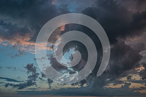 a dark thundercloud on the background of sunset