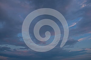 a dark thundercloud on the background of sunset