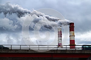 Dark toxic smoke clouds coming out of factory chimney. Air pollution and global warming caused by old industrial power plant