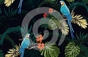 Dark tropical seamless pattern with exotic monstera and royal palm leaves, hibiscus flowers, blue macaws and branches
