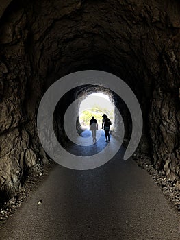 Dark Tunel with two people walking inside in the dark