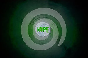 Dark tunnel with light and word â€œHOPEâ€ in the end - the concept of hopefulness